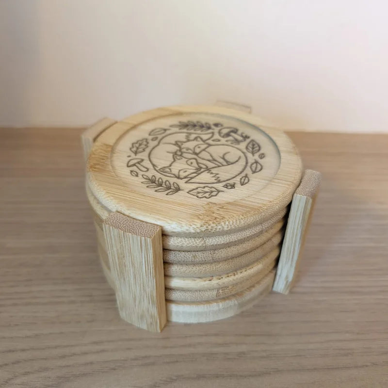 Dessous de verre en bambou gravés de motifs animaux rangés dans leur support