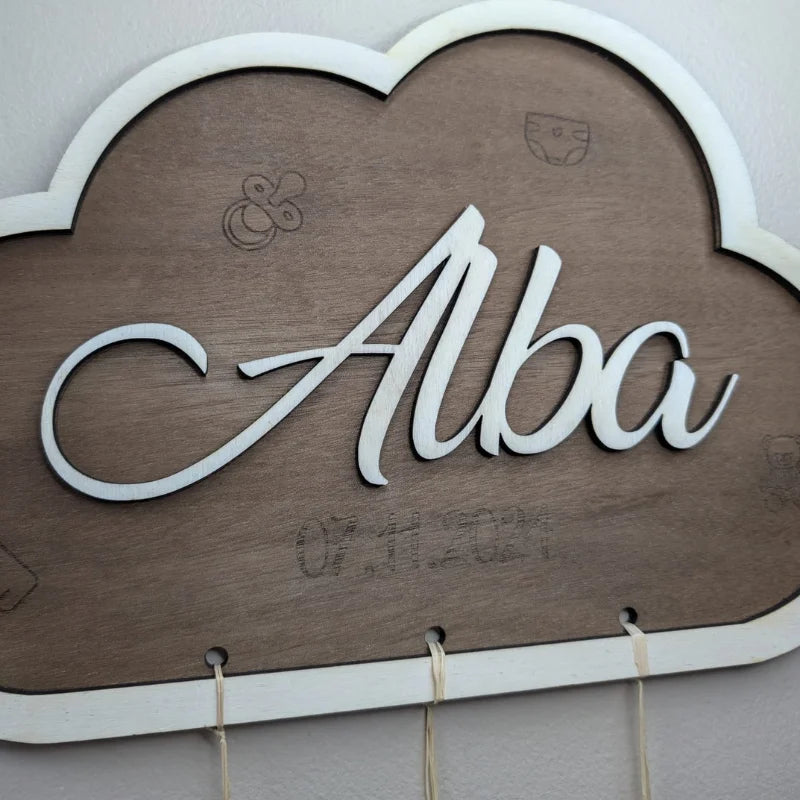 Gros plan d'une plaque de naissance nuage en bois avec prénom personnalisé en relief