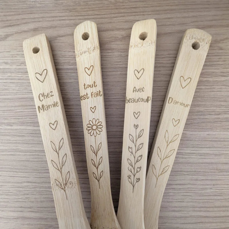 Détail des manches d'ustensiles en bambou gravés avec cœurs, fleurs et message pour Mamie